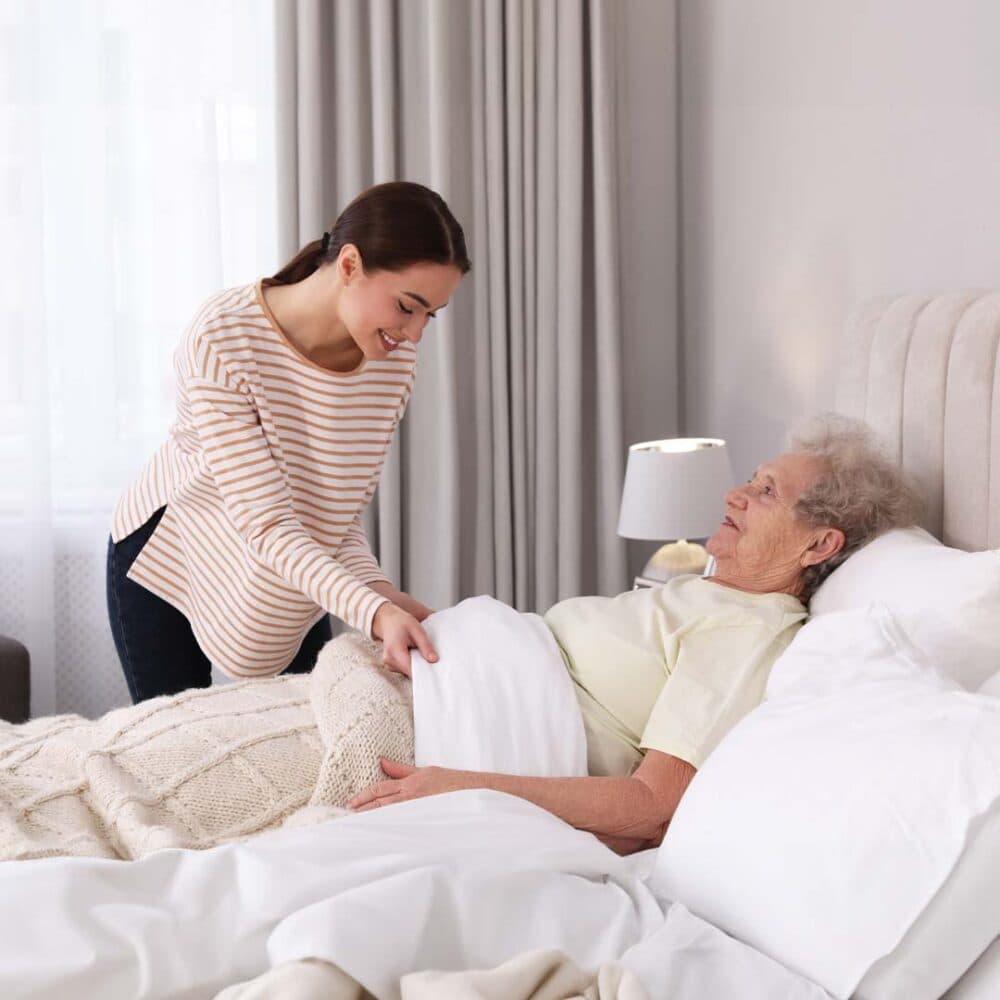 Care professional preparing an elderly lady for bed to support with overnight care