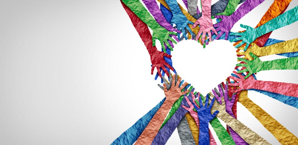 Colorful paper hands forming a heart shape in the center, symbolizing unity and diversity on a white background. - Home Instead