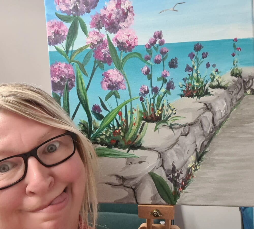 Dee pulling a funny face in front of her painting