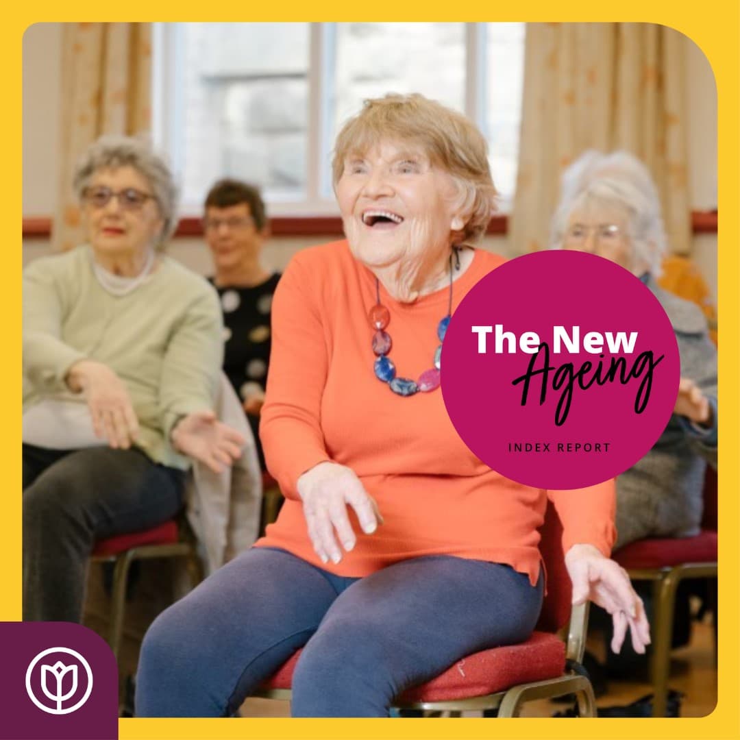 A group of elderly people seated, with a joyful older woman in an orange top in focus, and text reading "The New Ageing" - Home Instead
