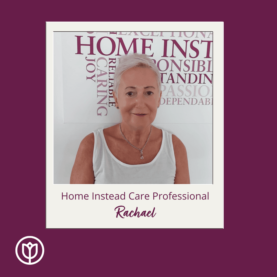 Photo of Rachael in front of Home Instead wall mural, she is a Care Professional at Lewes District and Uckfield office