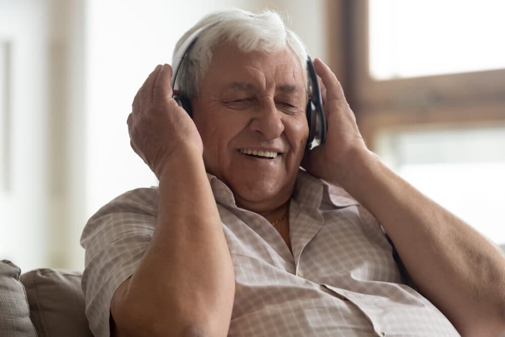 Senior man enjoys listening to a personal playlist on his headphones