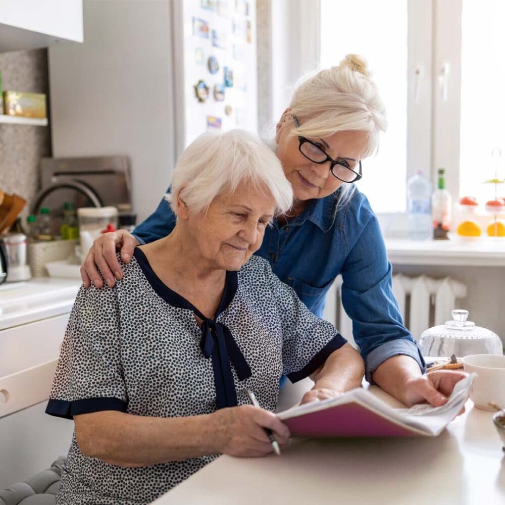 Daughter helping elderly mum read care options booklet