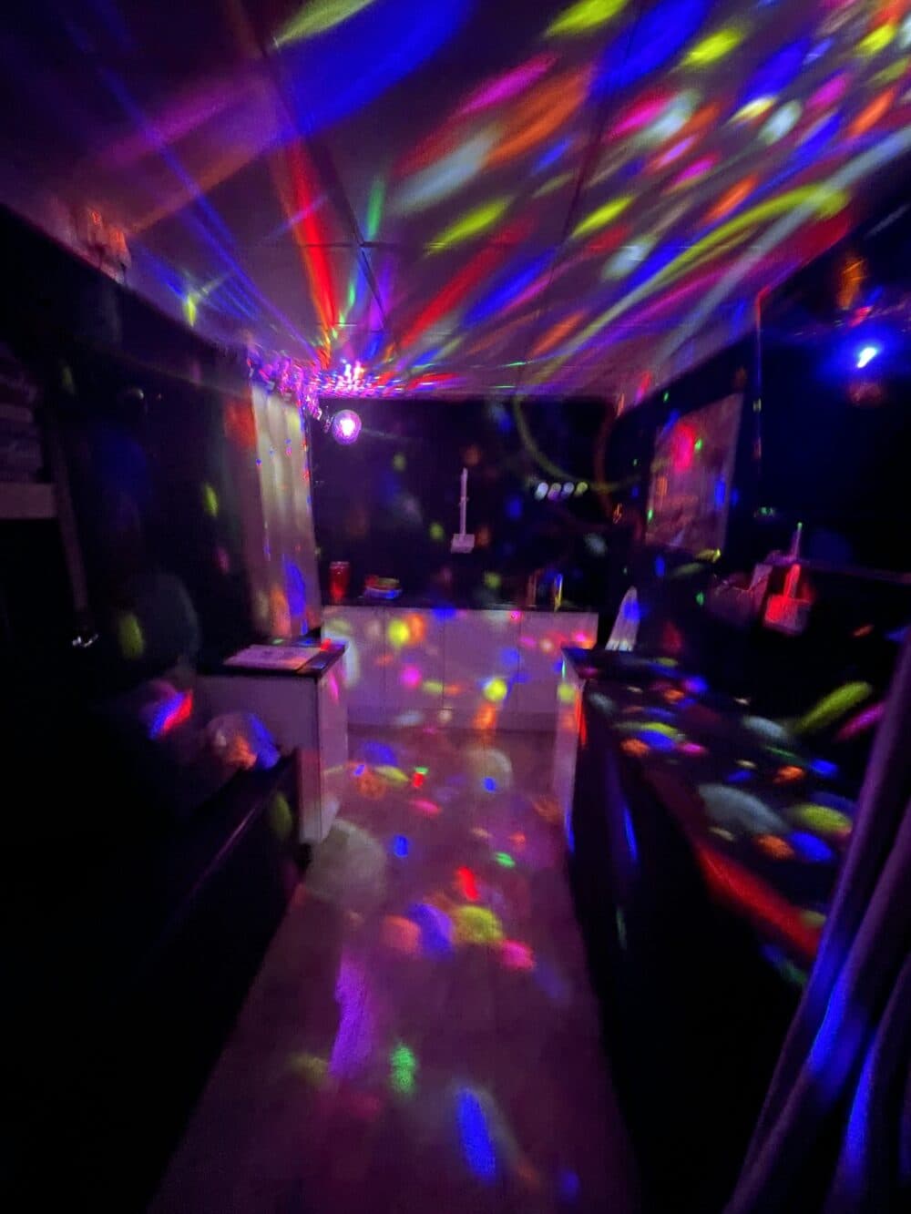 Room with colorful disco lights reflecting off the walls and ceiling, creating a vibrant, festive atmosphere. - Home Instead