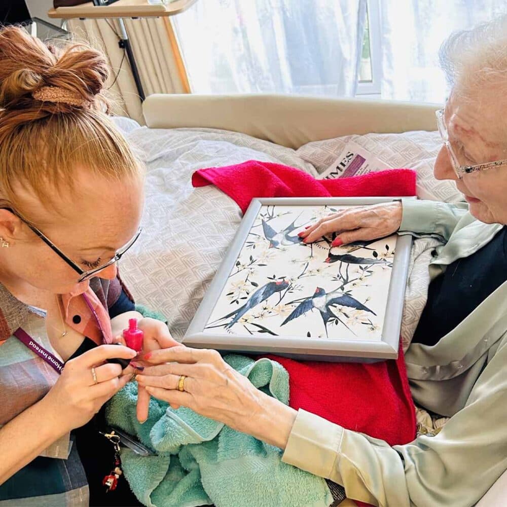 Home Instead Care Professional Katy Marlow providing nail care pampering to her client Rosemary