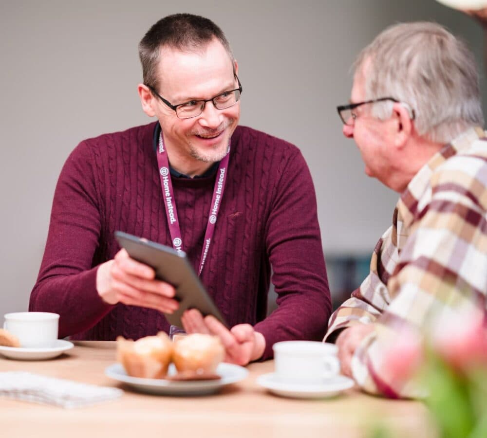 Home Instead Southampton Care Professional with client using tablet