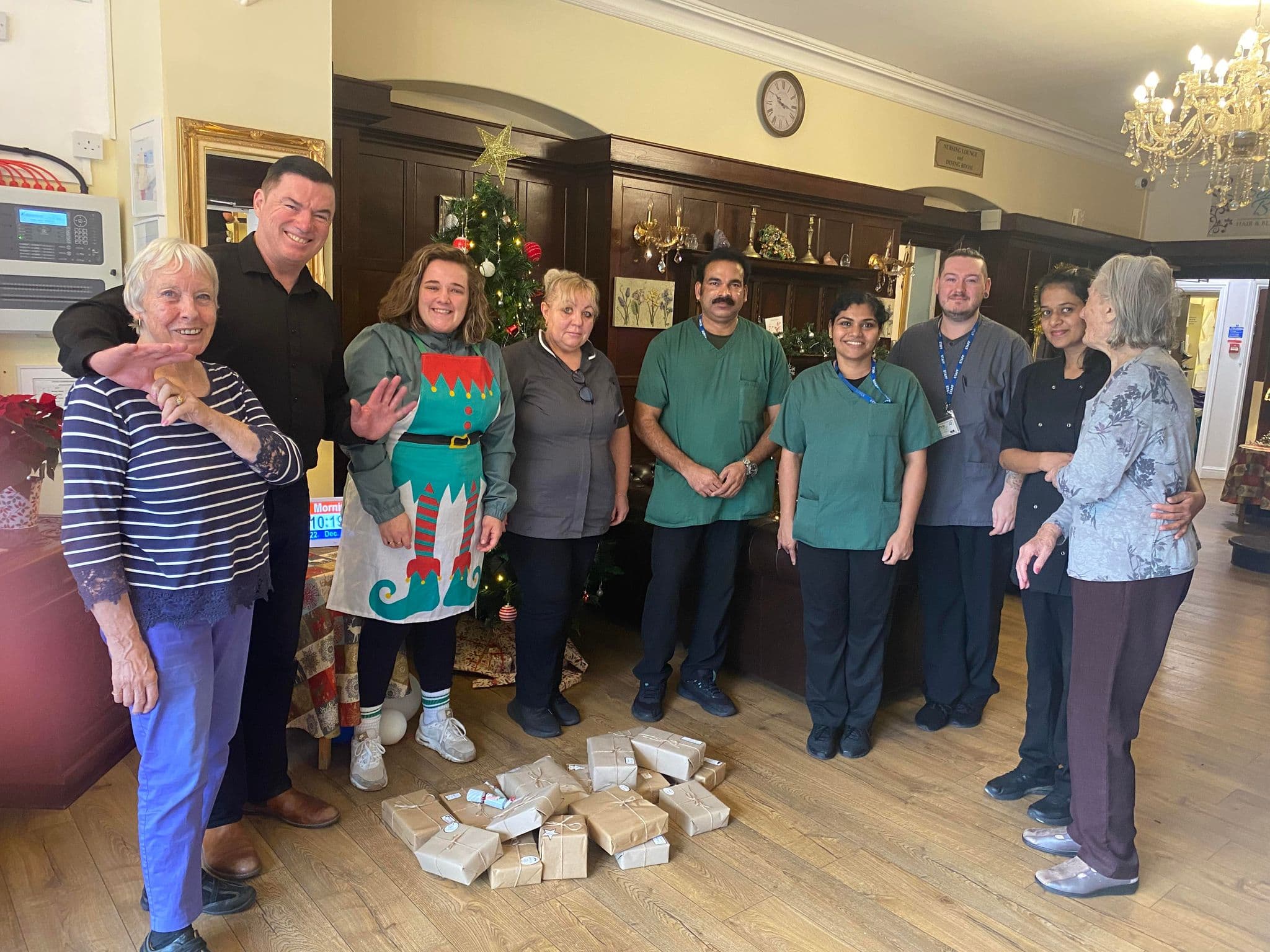 group of care home workers with pile of gift donations for residents