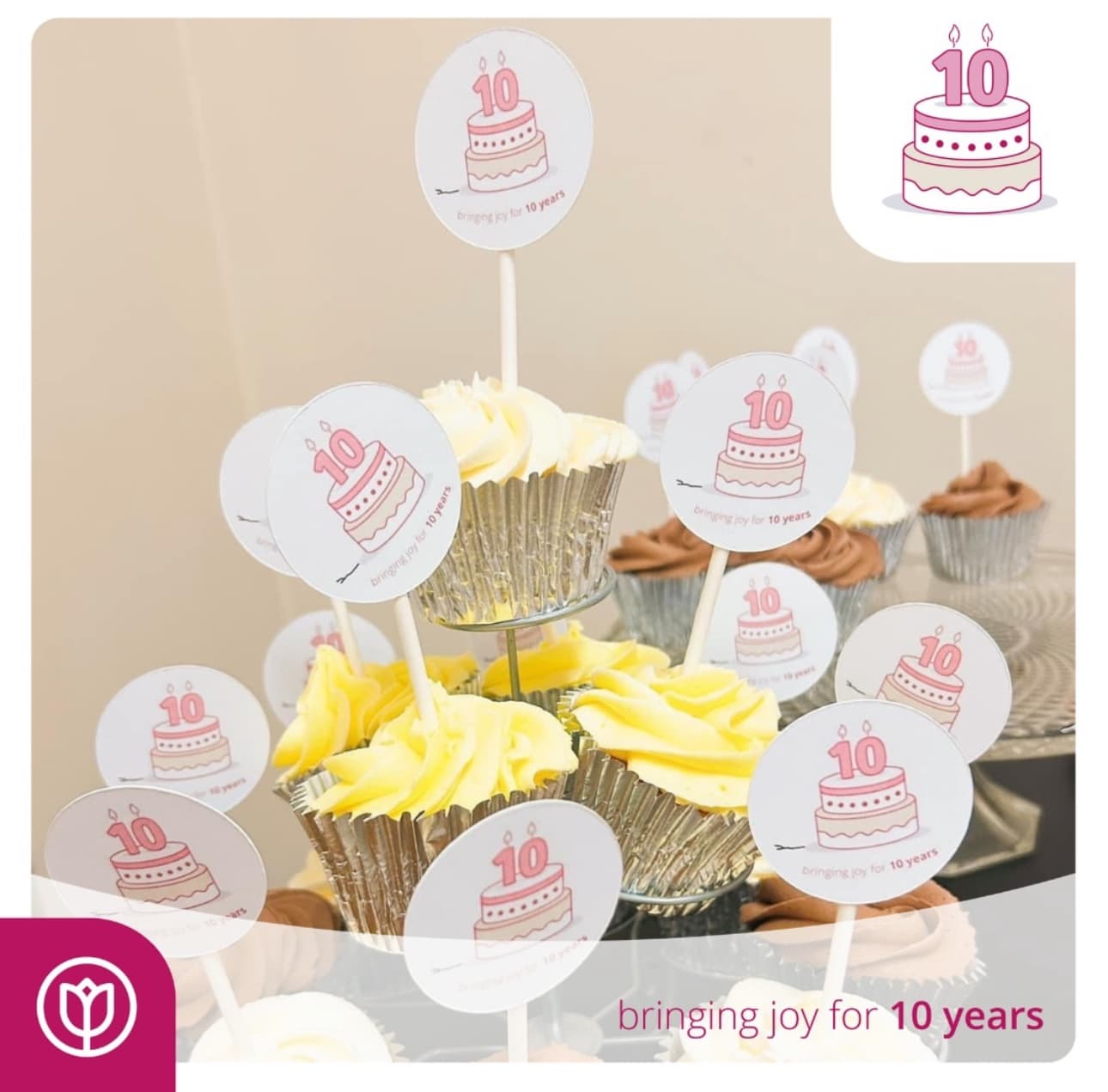 Cupcakes with "10" toppers in silver wrappers on a tiered stand celebrating a 10-year anniversary. - Home Instead