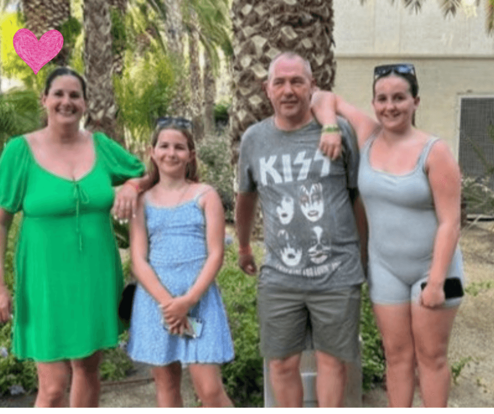 A group of four people posing outdoors with palm trees in the background. - Home Instead