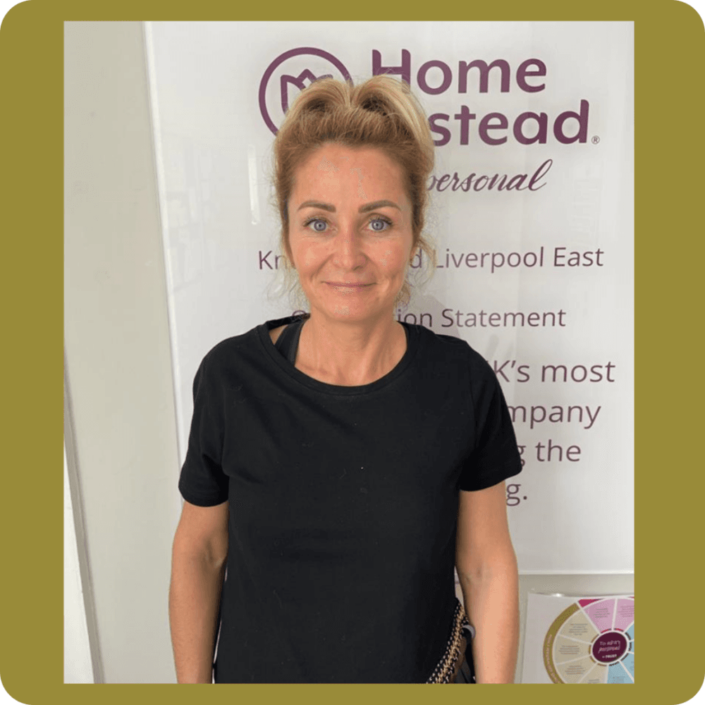 Person smiling in front of a "Home Instead" sign. - Home Instead