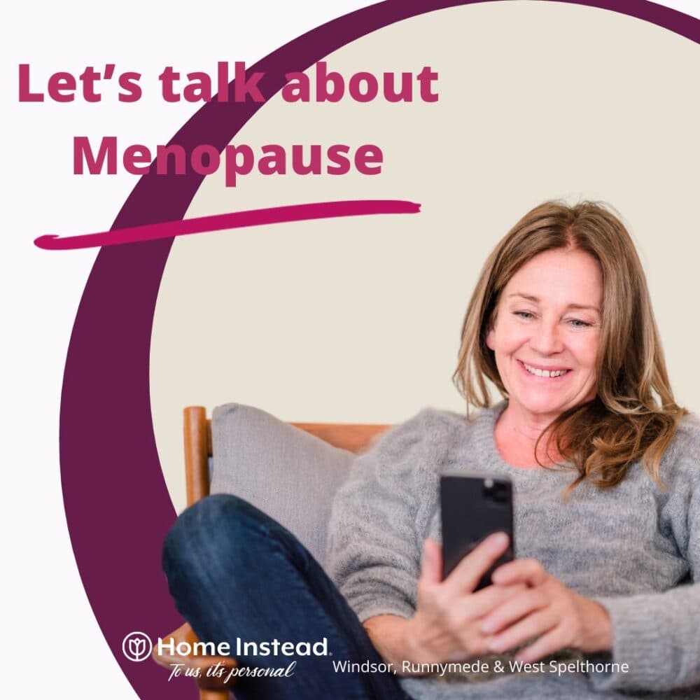Smiling woman on couch looking at phone, with text "Let's talk about Menopause. - Home Instead