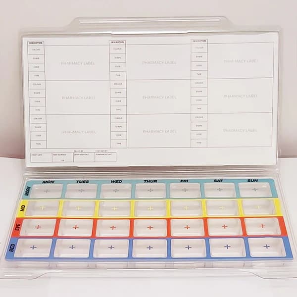 Weekly pill organizer with labeled compartments for each day and time, open to reveal pharmacy labels inside the lid. - Home Instead