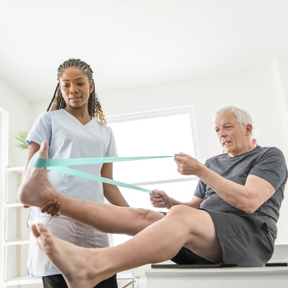 Senior working with his physio to strengthen ankles and leg joints