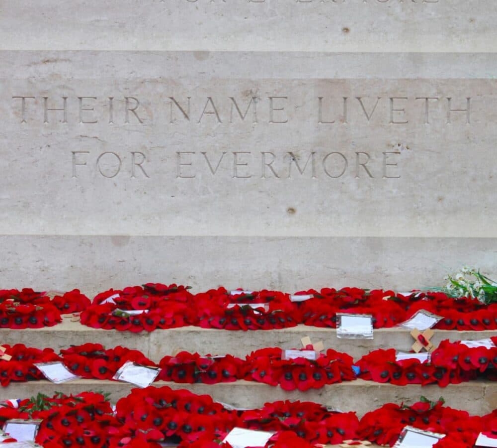 Wreath of red poppies on the floor with cards on it