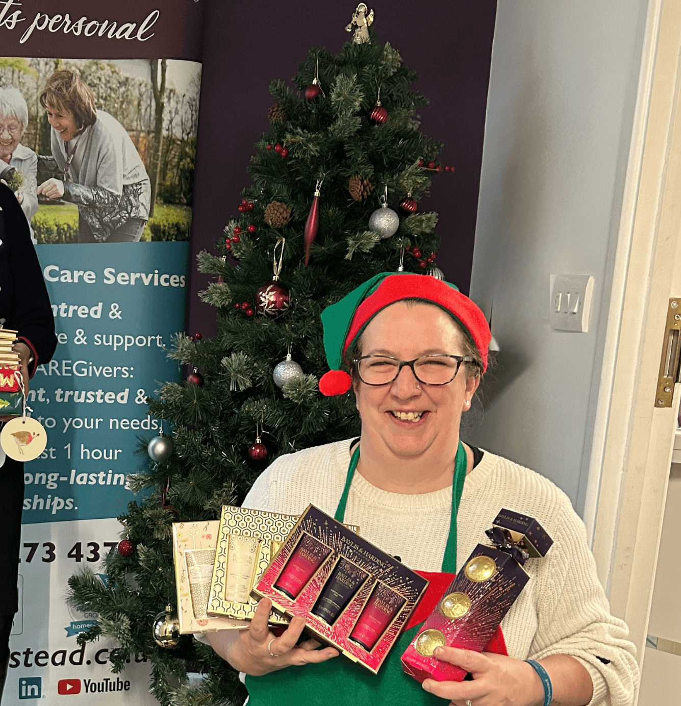 Director, Alison, and Care Manager, Kat holding donations next to Christmas tree