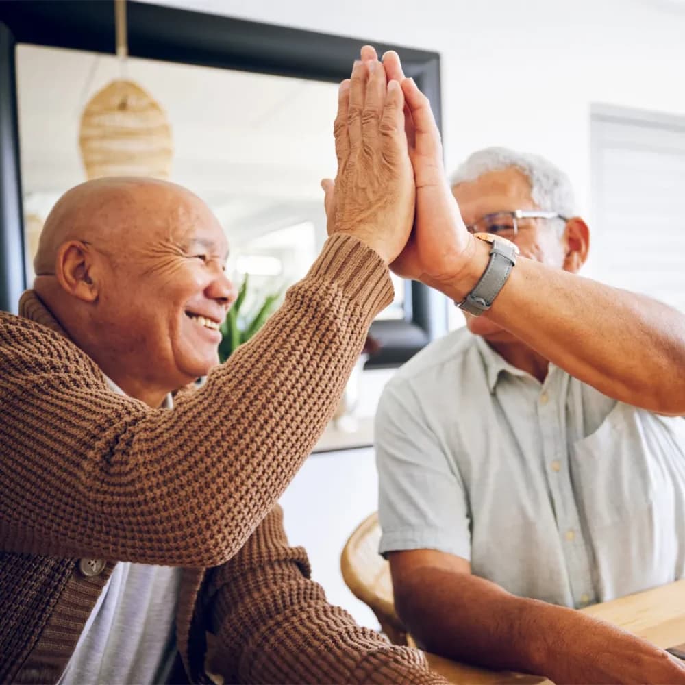 Care professional celebrating a board game win with his client