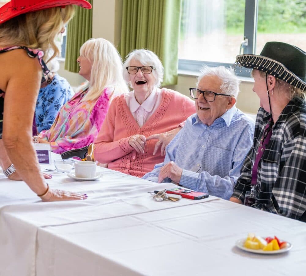 Happy seniors all laughing and smiling while sitting on a chair