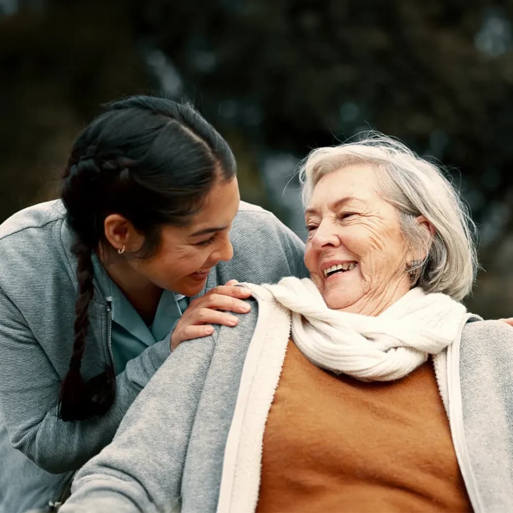 Care professional laughing and enjoying time with her client