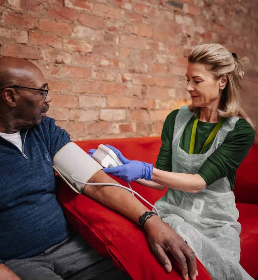 Home Instead care pro supporting client with blood pressure monitoring at home