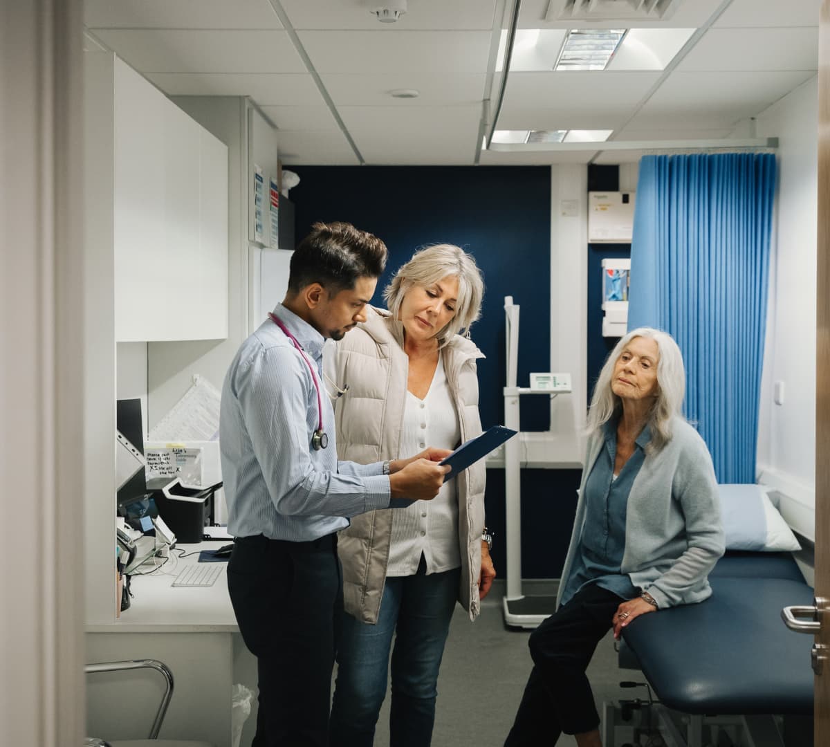 Senior woman inside the doctors clinic with a doctor and her daughter