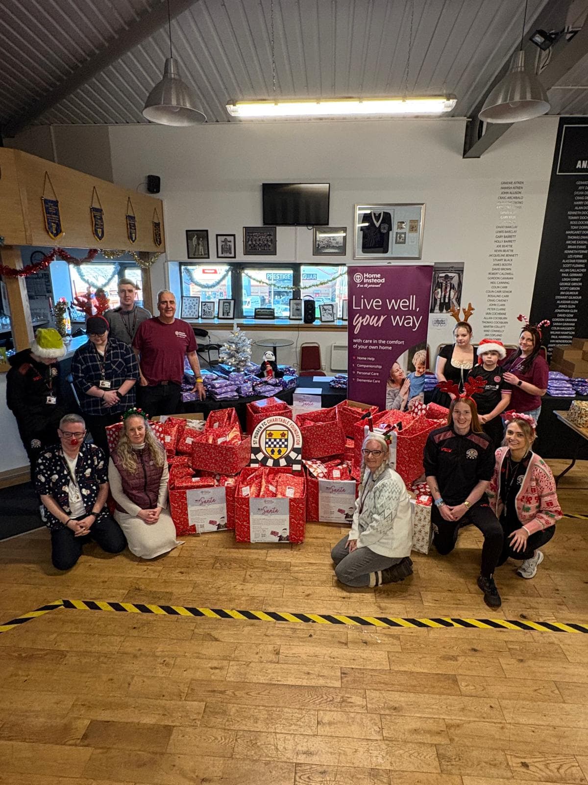 Home Instead Renfrewshire & Barrhead team donating gifts to St Mirren FC festive Friends in Paisley, December 2024