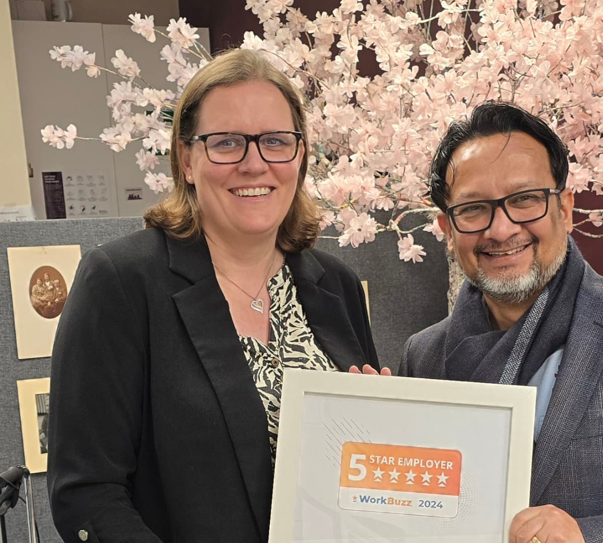 a man and a woman standing and holding a plaque of award