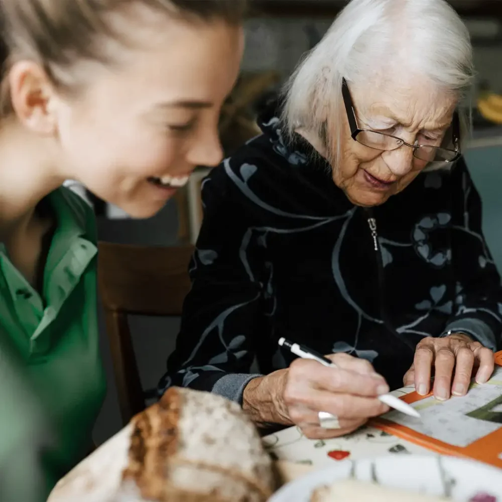 Home Instead Care Pro enjoying a word search with her client
