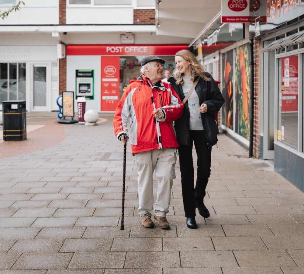 Senior man walking with his daughter both wearing jackets on cold day