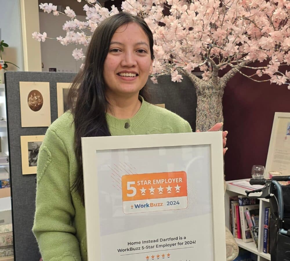 Woman smiling wearing apple green shirt while holding an award