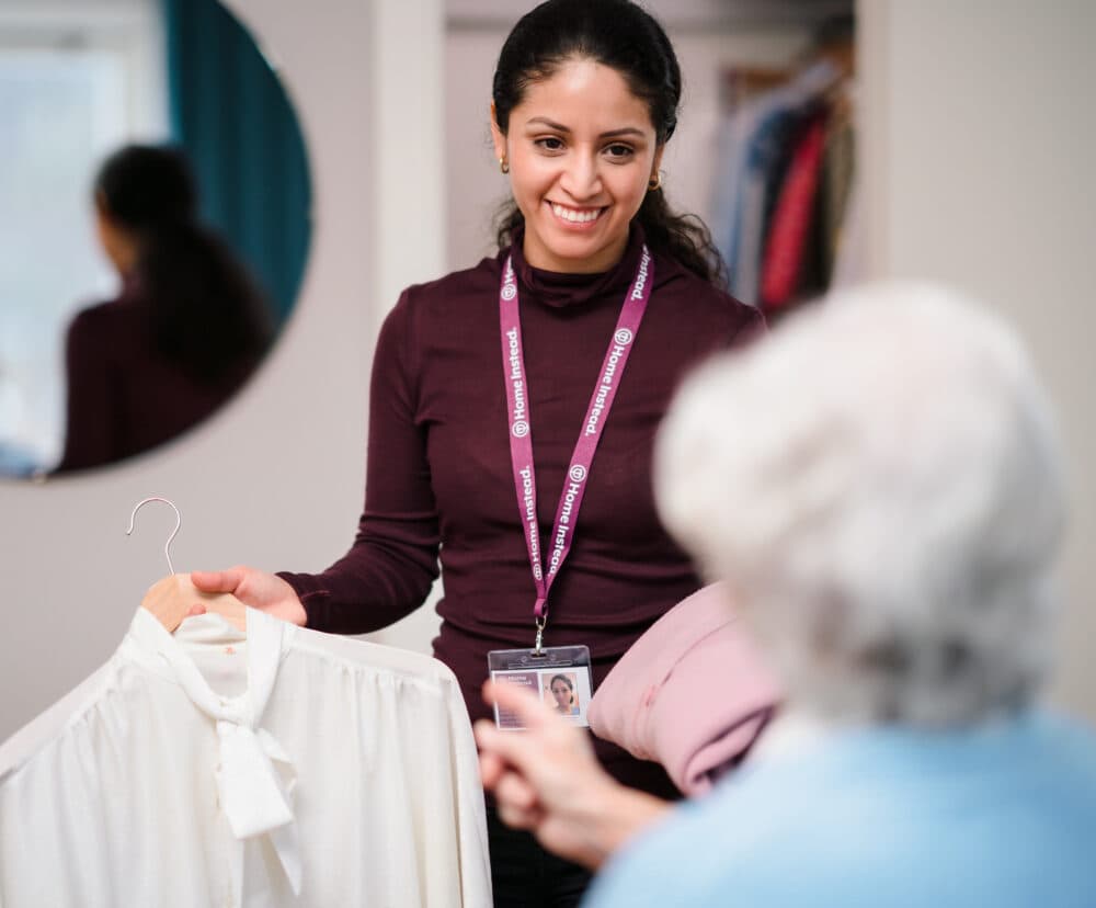 Home Instead carer helping her Home Instead client to choose clothes to wear
