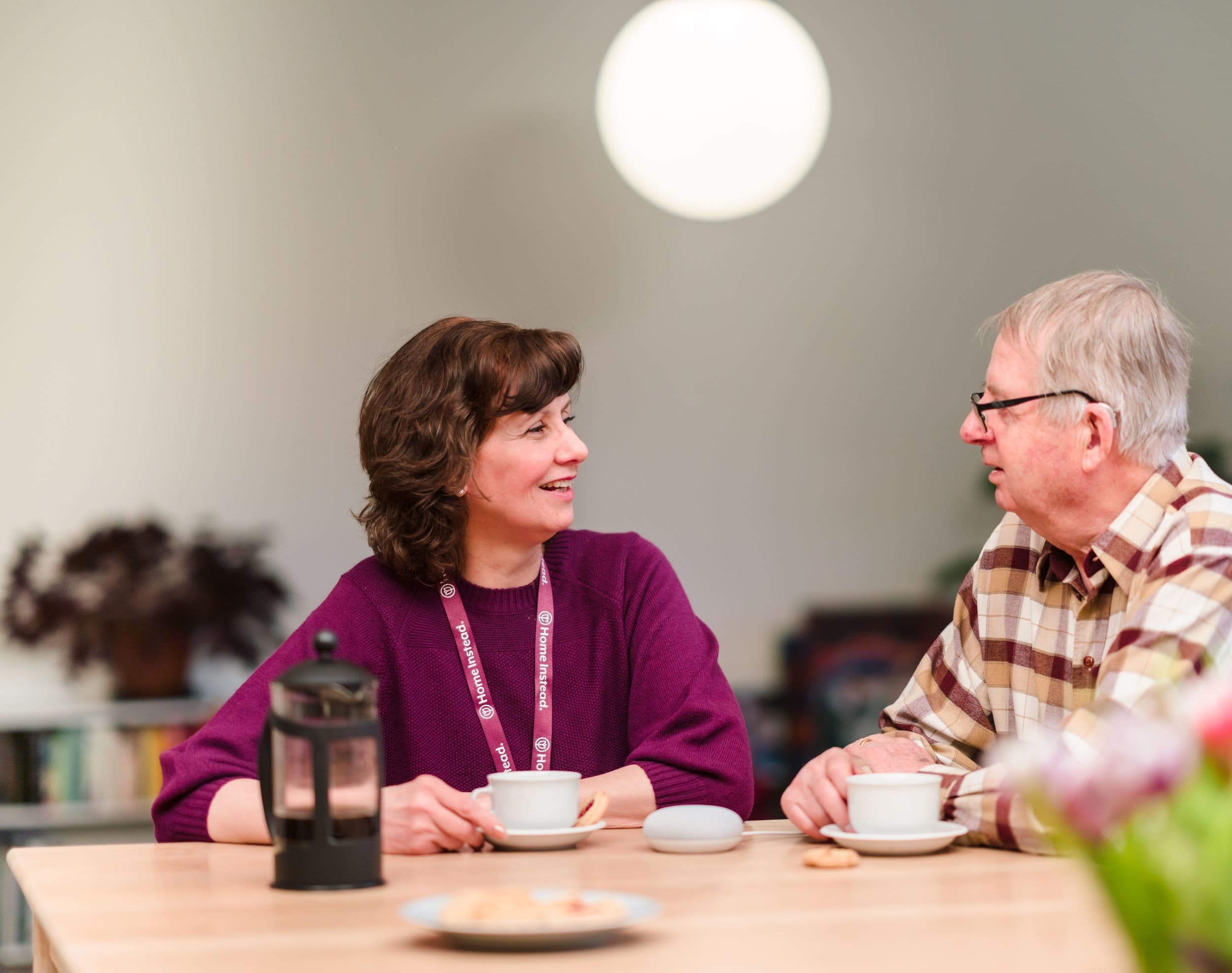 Home Instead live-in carer drinking coffee with her client