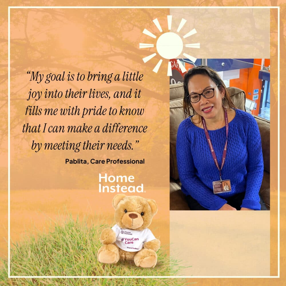 A woman in glasses smiles while sitting beside a teddy bear and a quote about making a difference. - Home Instead