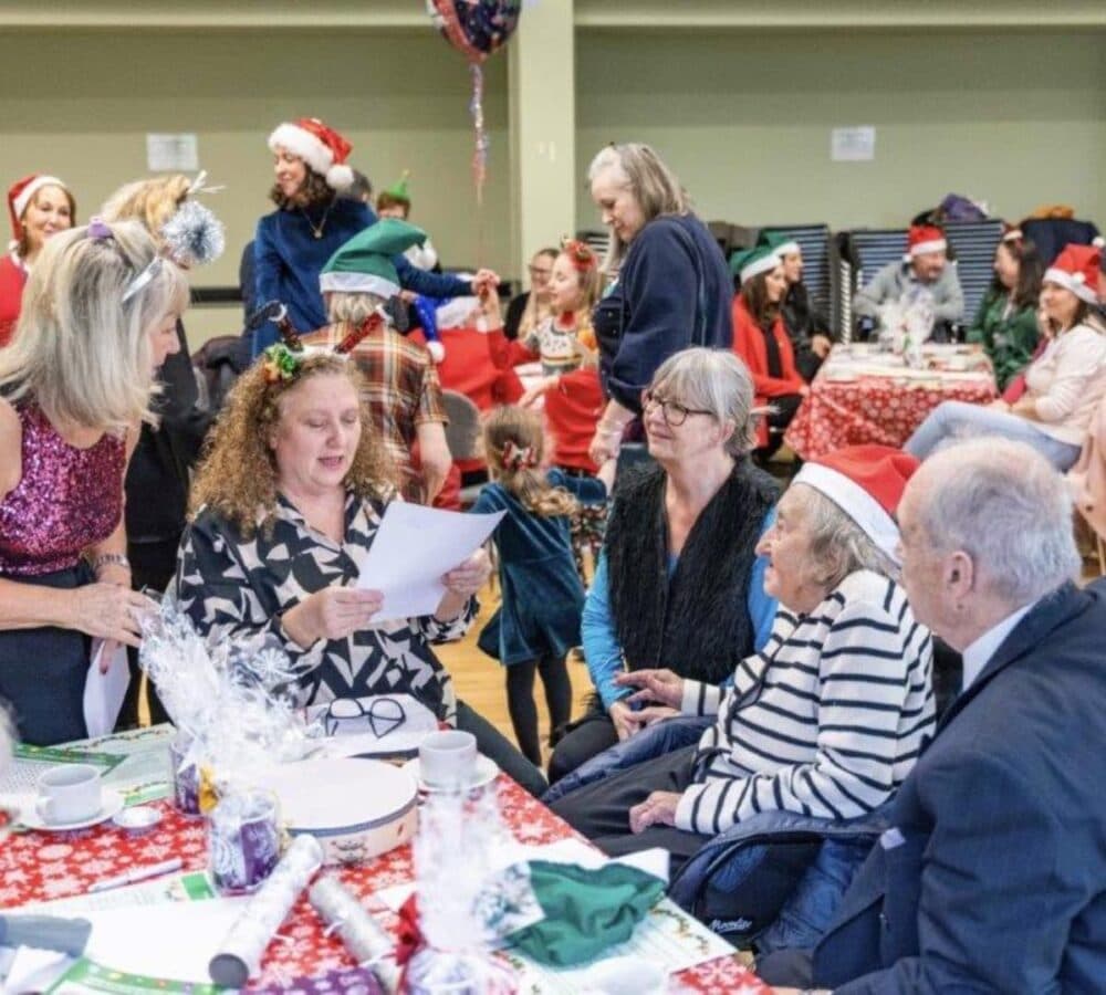 Group of people chatting and having some fun while wearing bright colours and sitting around a table