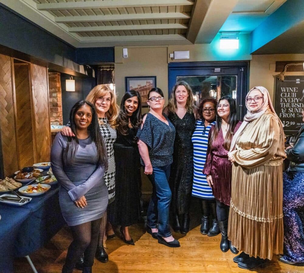 group of women with different ages and wearing different types of clothes all happy and smiling inside the restaurant