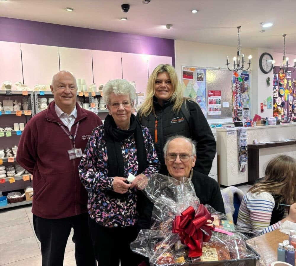 Two women and two men all smiling and happy while inside a craft store