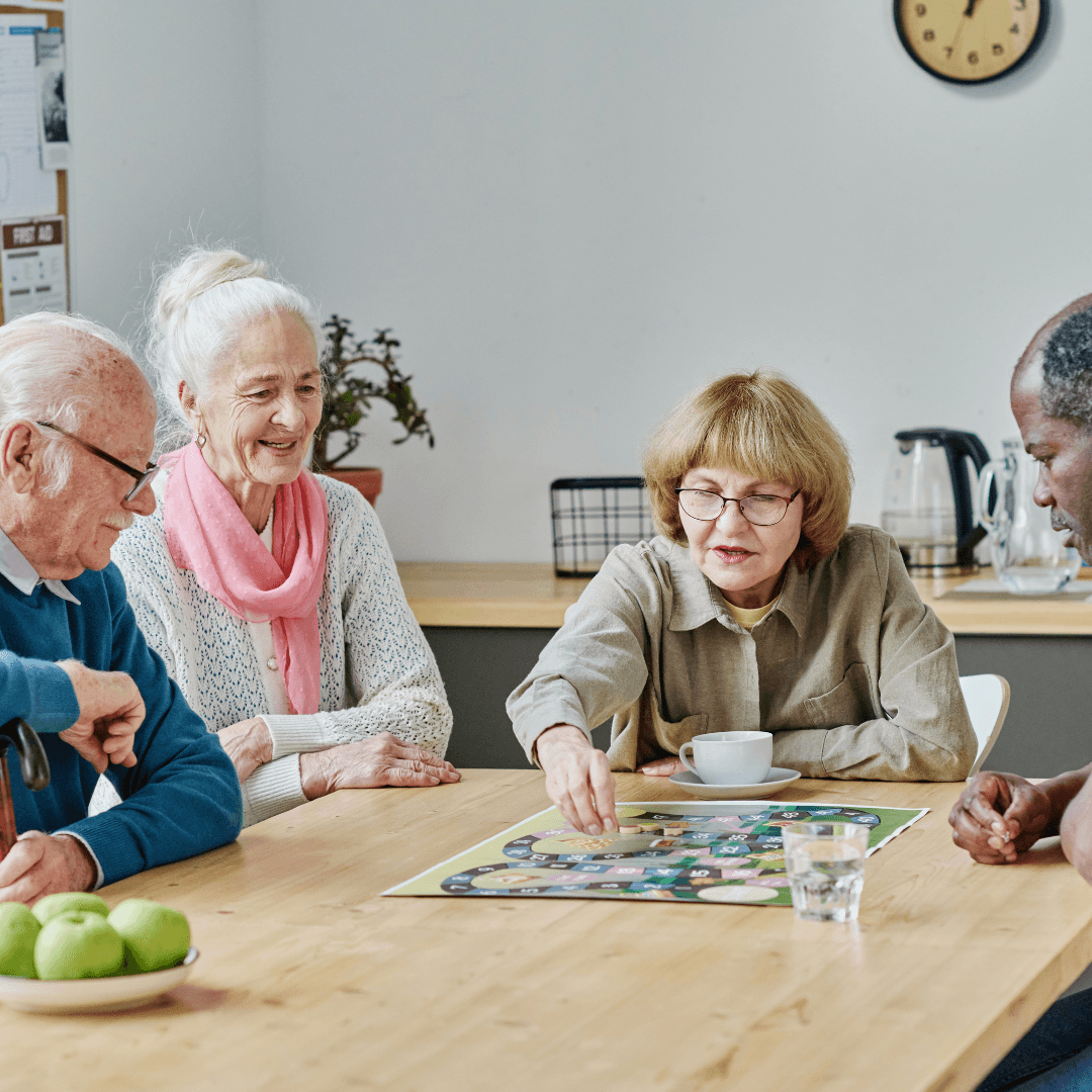 A group of elderly individuals enjoying a board game together in a care home, engaging in social activities as part of respite care services.