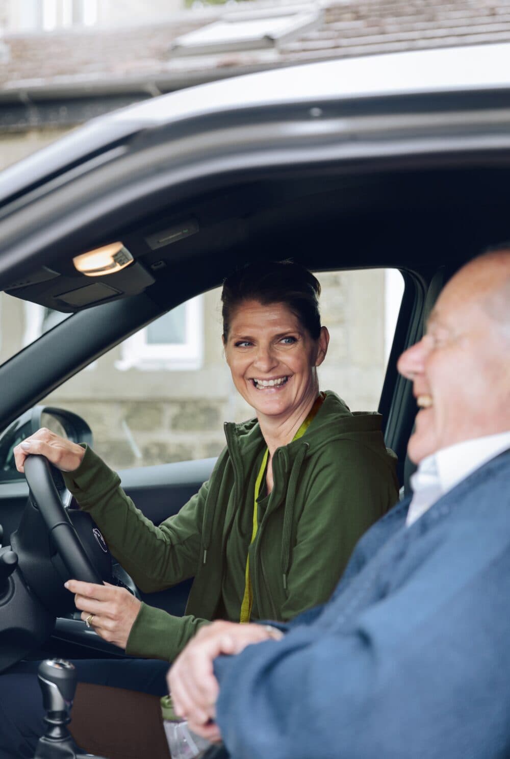 Care Professional and client listening to the radio in a car.