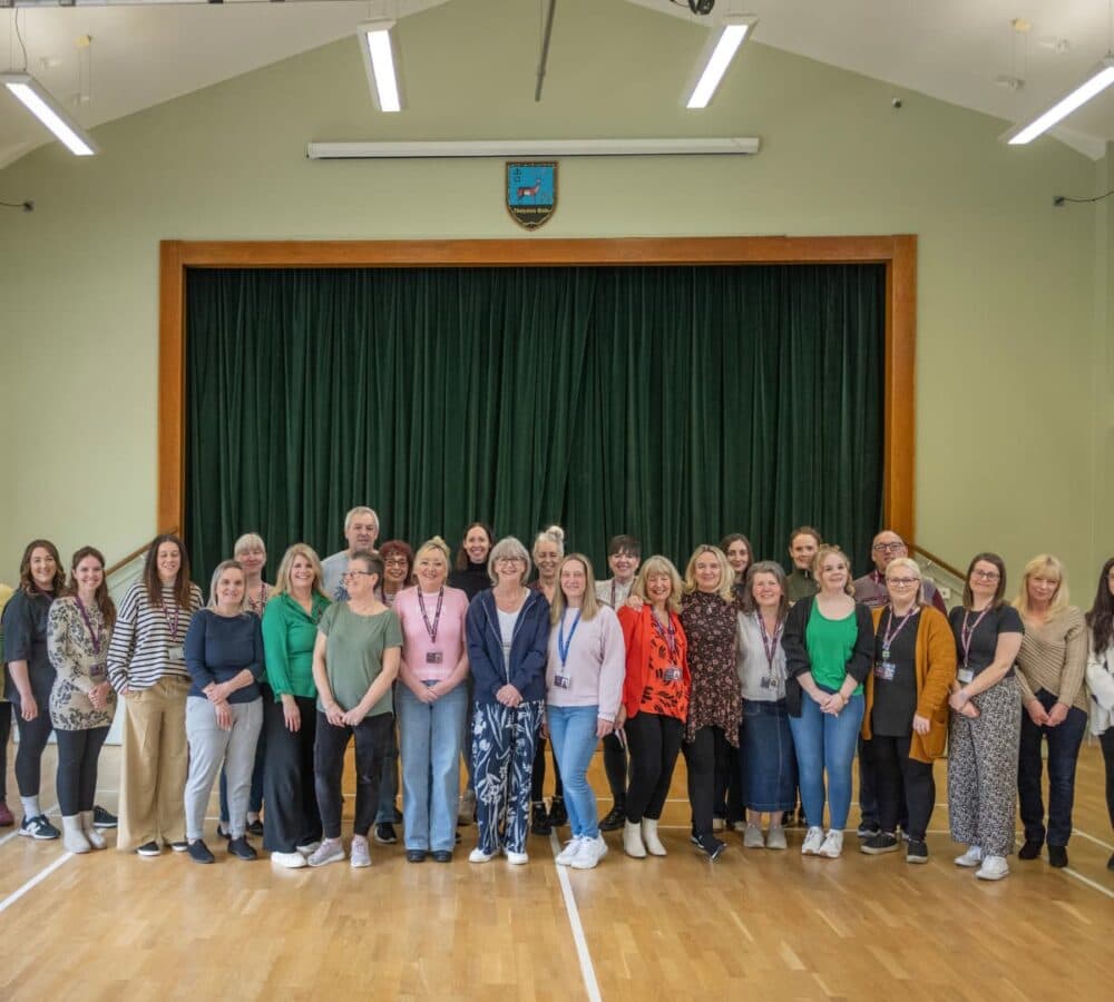 Group of Care Professionals all happy and smiling inside a hall