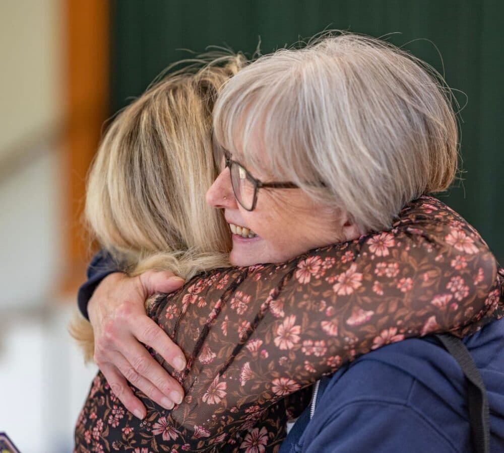 Two women hugging each other
