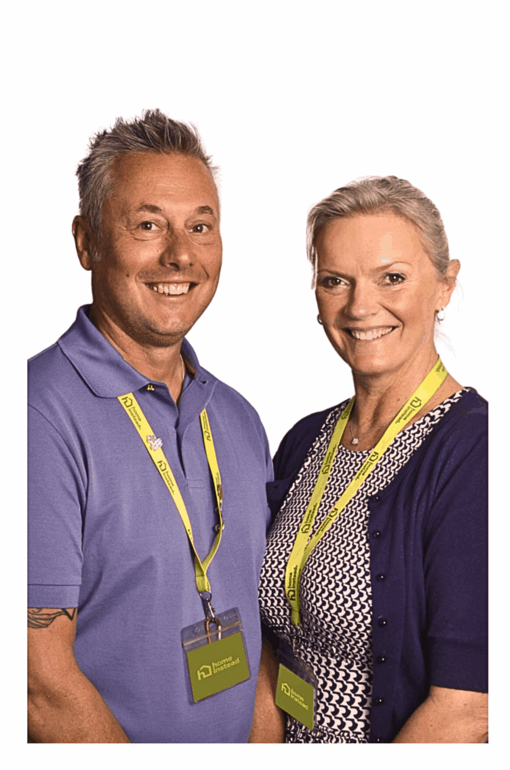 A smiling woman with short gray hair stands next to a smiling man with short gray hair in front of a purple background. - Home Instead