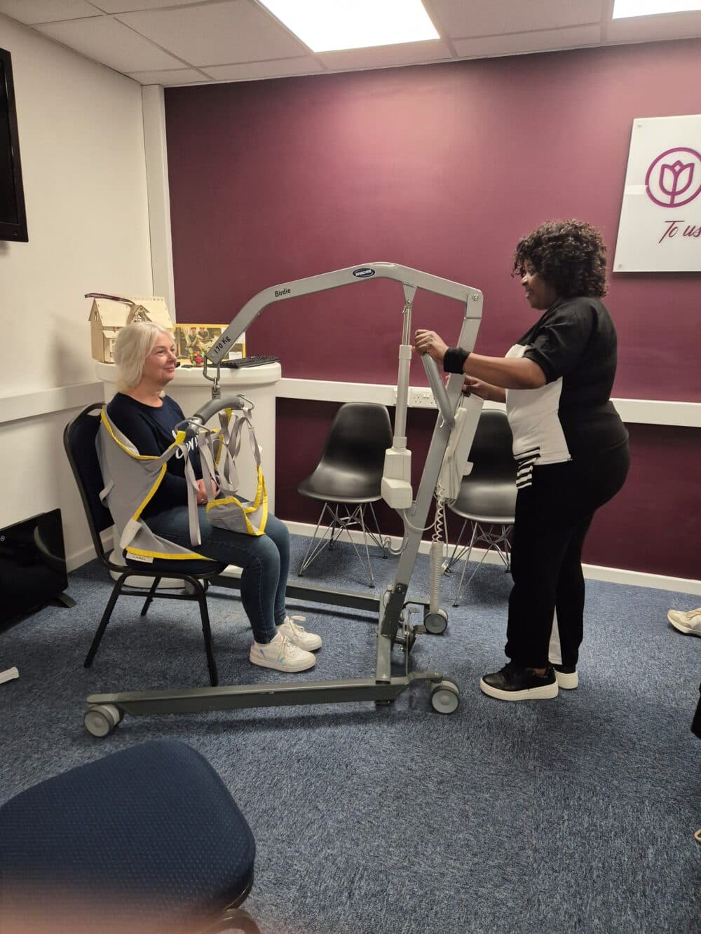 Deborah operates the remote handset, raising Daisy to standing height during training.