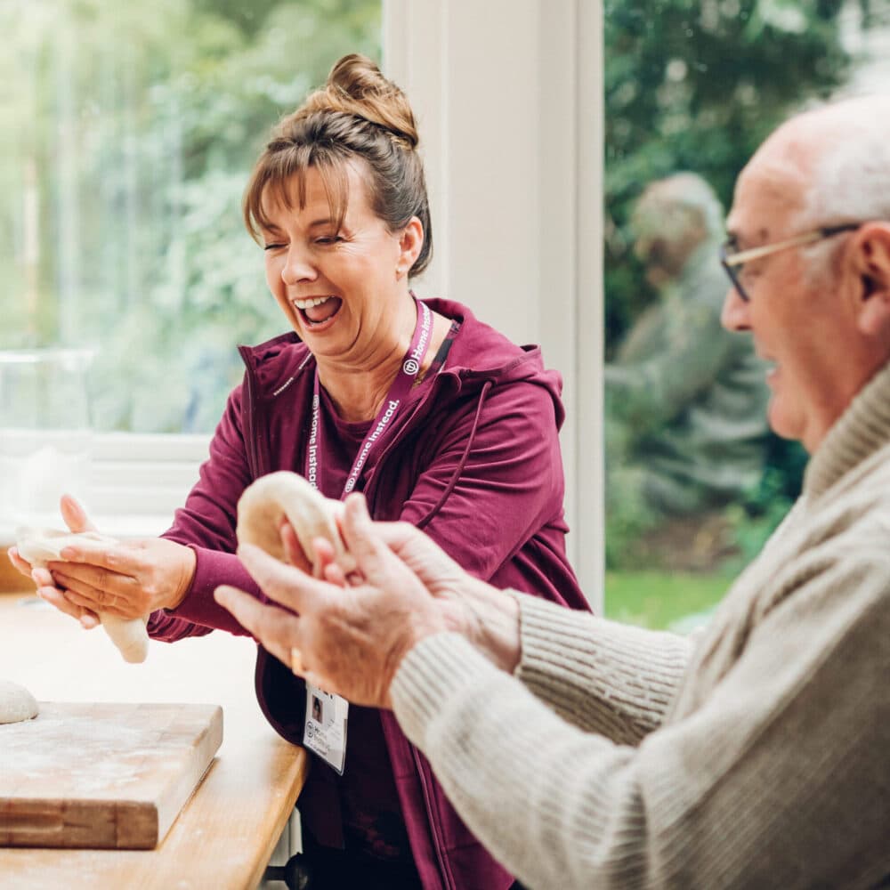 Home Instead carer making bread with her male client at the client's home