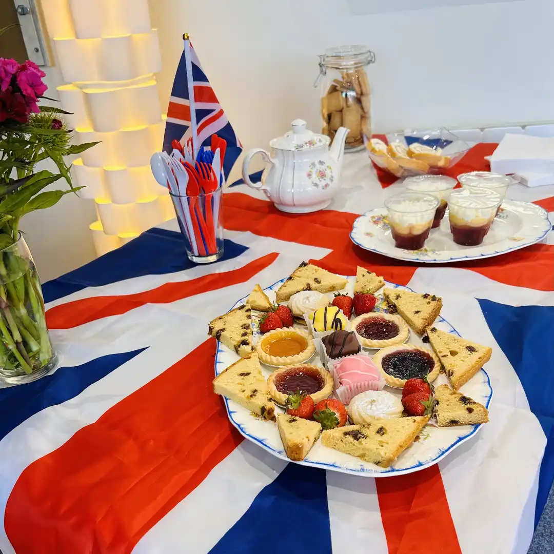 Table draped in Union Jack with plates of treats at Home Instead Ascots VE Day celebrations