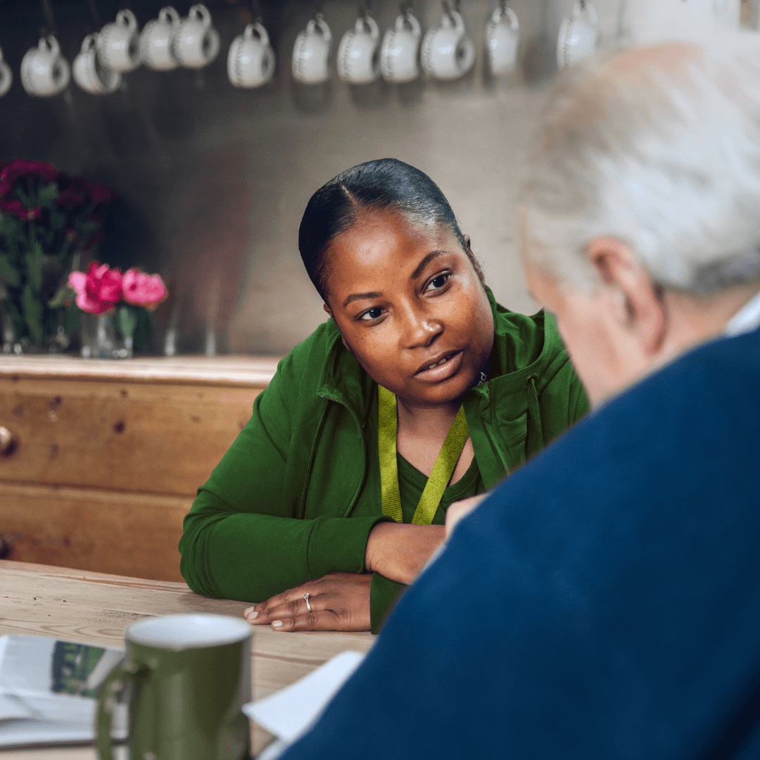Carer talking to a older gentleman in his home