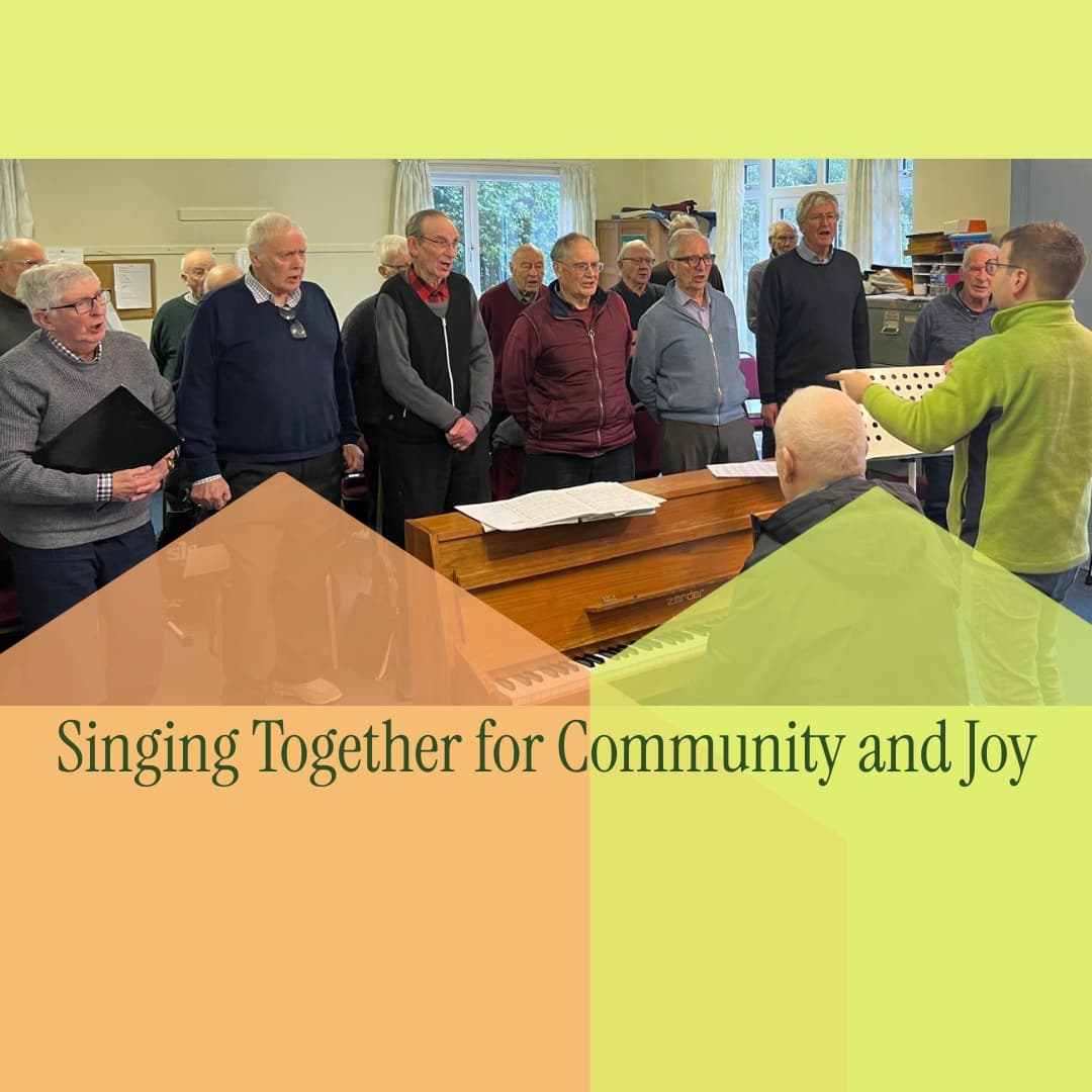 A men's choir rehearses with a conductor and pianist in a brightly lit room. - Home Instead