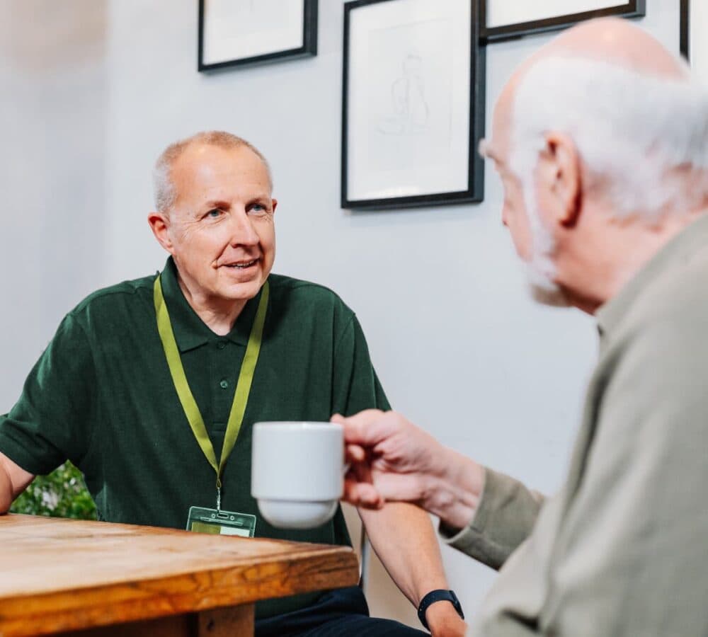 Two men sitting and talking together while having coffee