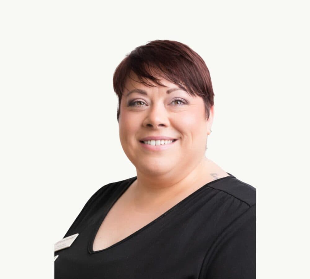 A woman with short hair and wearing black smiling happily