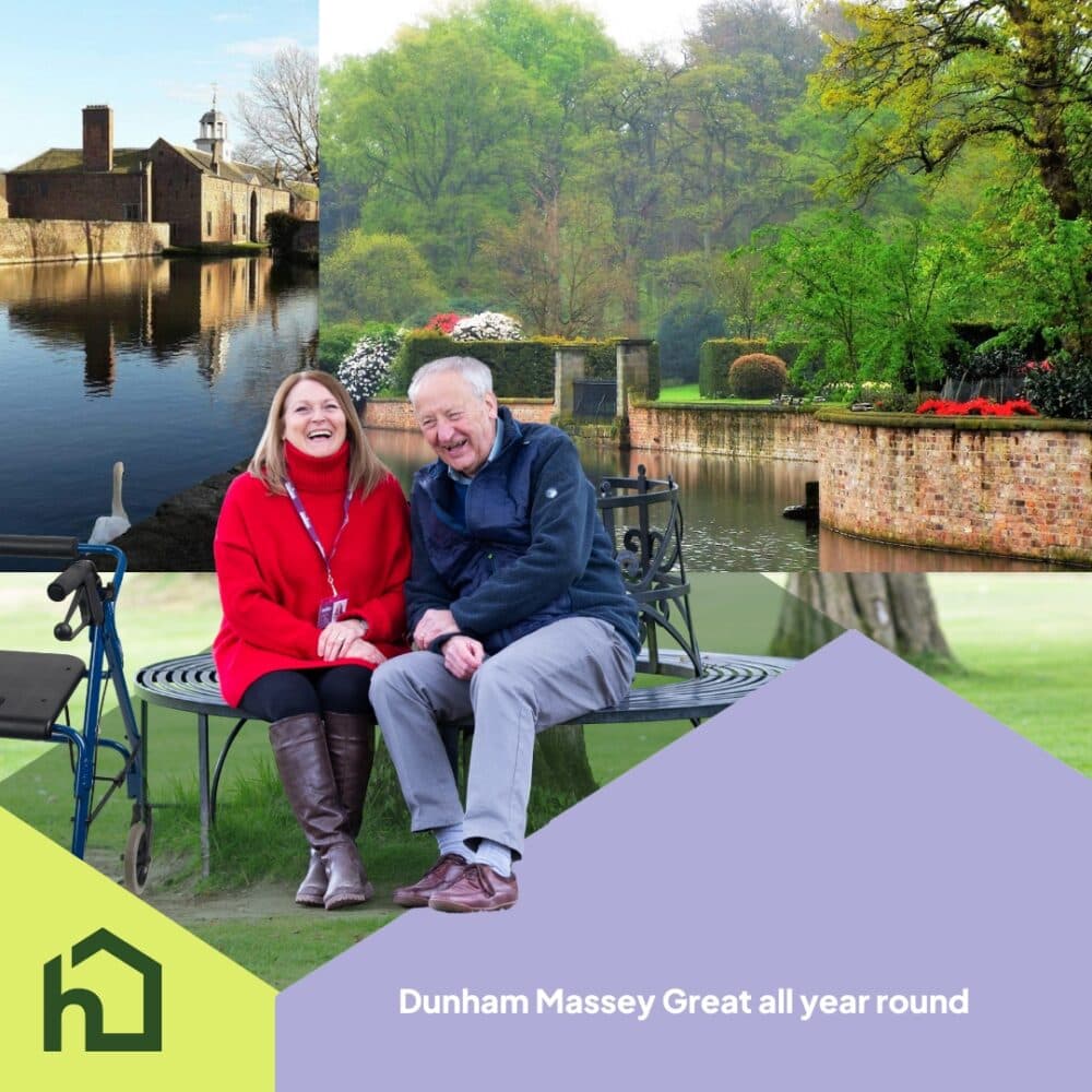 Smiling elderly couple sit on a bench in a lush garden at Dunham Massey, with scenic grounds in the background. - Home Instead