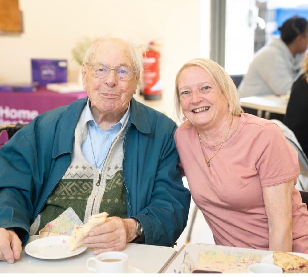 A father and daughter both happy and smiling inside the room while sitting on a chair