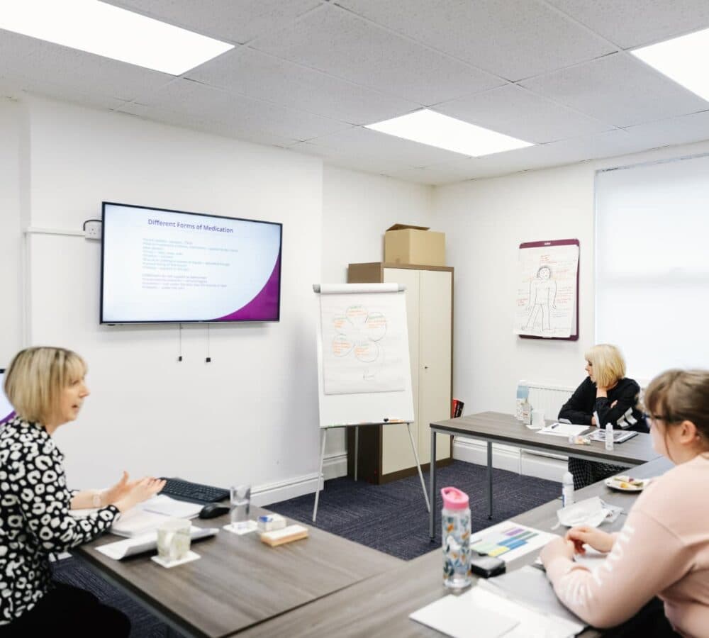 A group of people with a teacher having their training inside a room